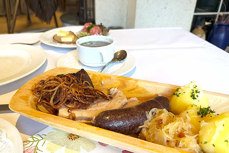 Schlachteplatte mit Wurstbrühe in der Tasse und Hackepeter