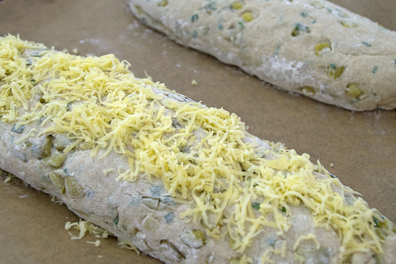 ein Brot mit Käse bestreuen